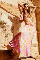 Model Lulu Tenney posing against a warm stone wall in an Emilio Pucci printed maxi skirt and matching top.