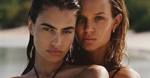 Close-up portrait of two female models with wet hair posing outdoors near a beach environment for Kith Summer Escape campaign.