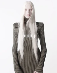 Model Kristen McMenamy in an olive green ribbed knit turtleneck dress against a white studio background for Juun.J.