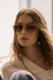 Model wearing gradient tinted sunglasses and a white textured top for Brunello Cucinelli eyewear