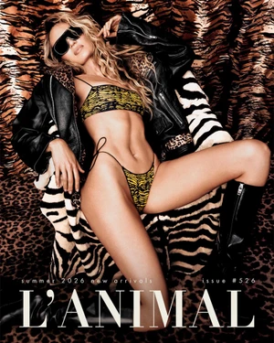 Candice Swanepoel wearing a yellow animal-print bikini, black leather jacket, and sunglasses against a tiger-print backdrop