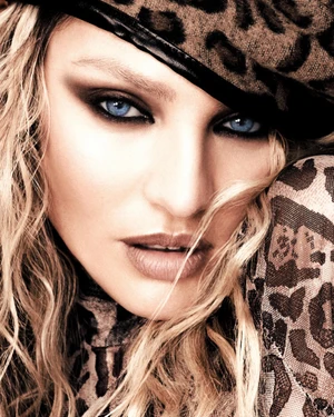Close-up portrait of Candice Swanepoel wearing a leopard print cap and top with dramatic smokey eye makeup.