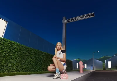 ROSÉ crouching next to a street sign in a stylized outdoor setting for the Puma H-Street Ivory campaign