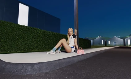 ROSÉ seated on a concrete curb wearing a white top, shorts, and sneakers with a pink handbag beside her