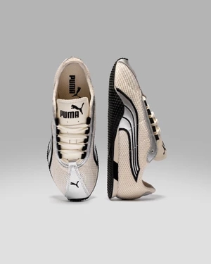 Two Puma sneakers shown in front and profile views against a seamless grey studio background