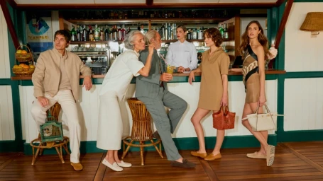 Group of six models in casual wear and loafers at a wooden bar interior for Tods Vacanze Italiane campaign