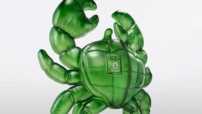 Glossy green puffer crab sculpture with quilted panels and a zipper against a plain white background