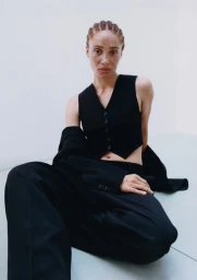 Adwoa Aboah wearing a black waistcoat and trousers against a white backdrop for the and Stella H and M project.