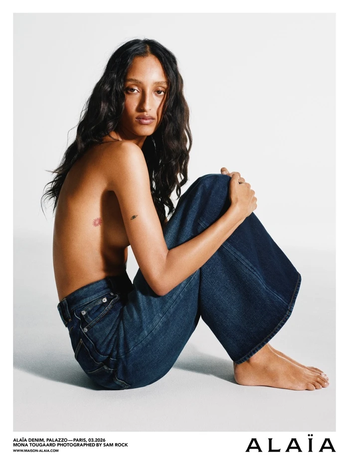 Model Mona Tougaard wearing dark denim jeans against a white background for the Alaïa Denim campaign