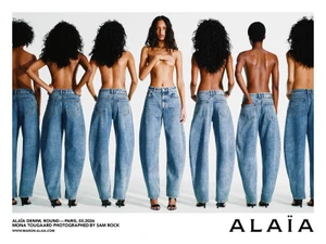 Model Mona Tougaard posing in blue denim jeans against a white seamless background for the Alaia campaign.