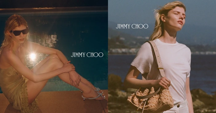Model in a white t-shirt carrying a beaded shoulder bag by a coastal body of water for Jimmy Choo.