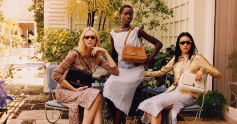 Three models posing outdoors with handbags for Tory Burch Spring 2026 campaign photographed by Jamie Hawkesworth.