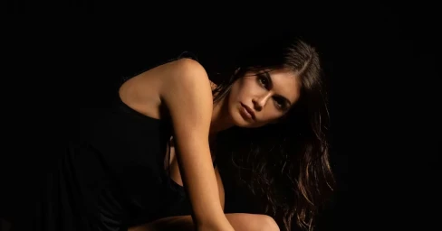 Kaia Gerber in a black dress against a dark background for Repetto In Bloom