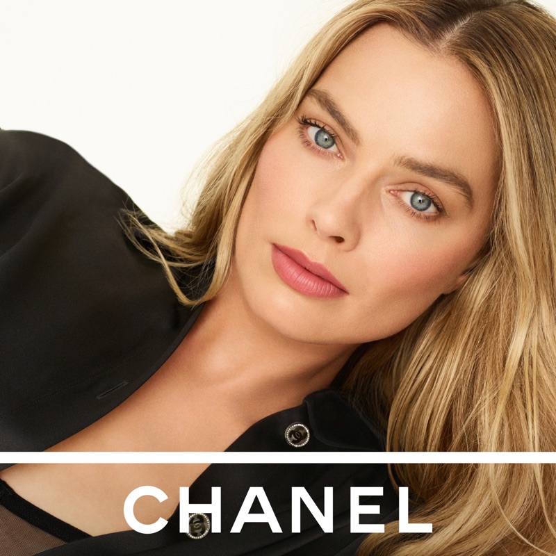 Margot Robbie wearing pink lipstick and a black shirt against a plain white background for Chanel Rouge Allure Velvet