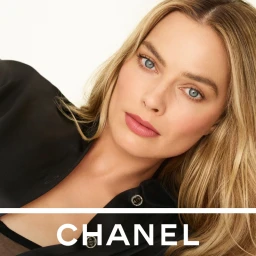 Margot Robbie wearing pink lipstick and a black shirt against a plain white background for Chanel Rouge Allure Velvet