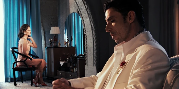 Alberto Guerra in a white suit seated beside Christy Turlington seated in the background for Zara VATISIMO