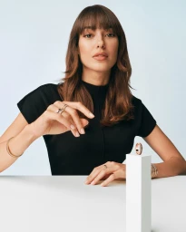 Dilan Cicek Deniz wearing Boucheron rings in Quatre Is Getting Mini campaign against a light blue backdrop.
