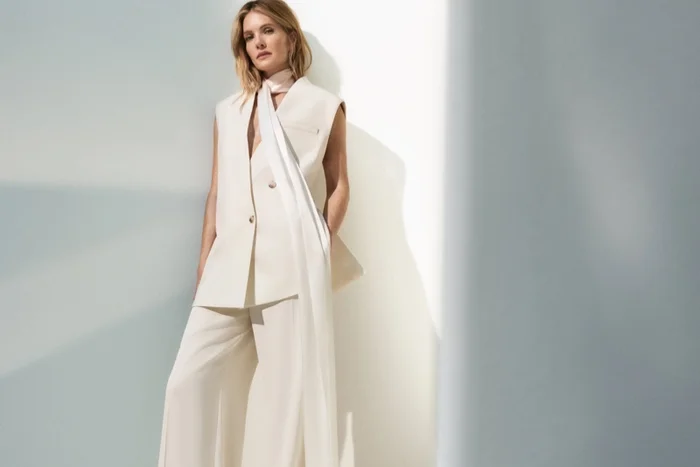 Meghann Fahy wearing a cream sleeveless vest and trousers with a long silk scarf for Hugo Boss Be the Next campaign