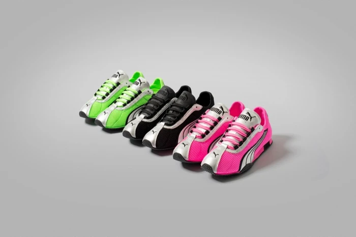 Three pairs of Puma sneakers in neon green, black, and pink arranged diagonally on a gradient grey studio background.