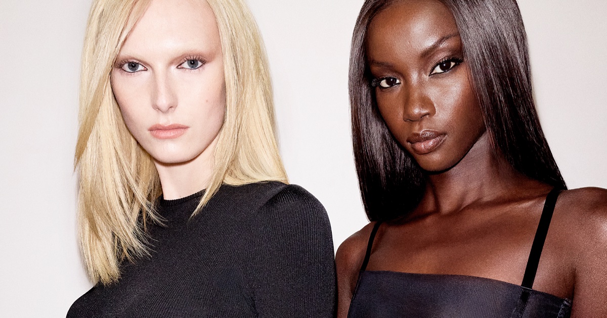 Alex Consani and Anok Yai pose together for Revolve Los Angeles against a plain white studio background.