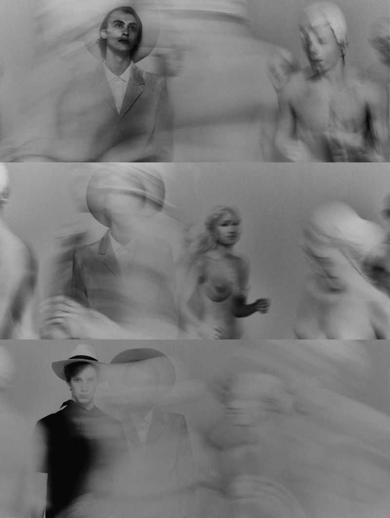 Monochrome blurred portrait with several adult humans wearing suits, hats, and bathing caps, in an indoor photo studio with diffused light.