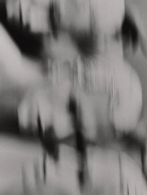 Abstract vertical motion blur black and white close-up portrait showing distorted facial features and streaks.