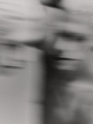 Monochrome abstract motion blur portrait featuring two indistinct human faces stretched with horizontal motion blur streaks.