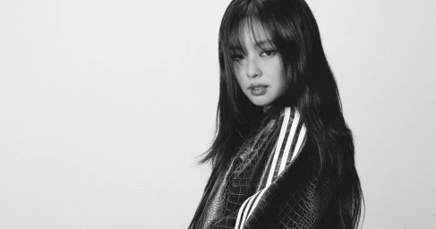 Jennie posing for Adidas Hotel Superstar campaign in a monochrome portrait against a plain studio background.