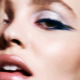 Close up portrait of Lily-Rose Depp featuring blue eyeshadow and glossy pink lips for Chanel Denim Makeup.