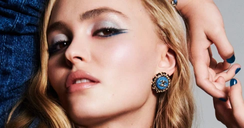 Close-up portrait of Lily-Rose Depp wearing blue winged eyeliner and Chanel earrings for the Denim Makeup project