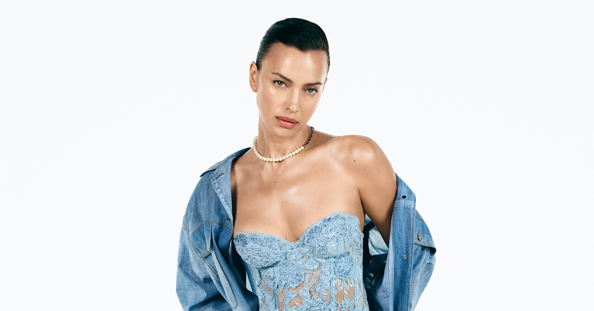 Model Irina Shayk wearing a blue lace strapless top and denim jacket against white