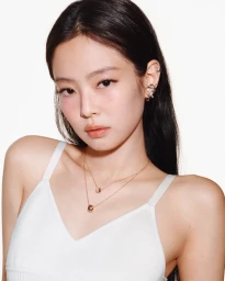 Jennie wearing gold layered necklaces and earrings against a plain white background for Chanel Coco Crush campaign