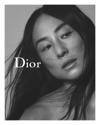 Close-up portrait of Greta Lee with dark flowing hair in a black-and-white fashion campaign image with the Dior logo visible
