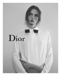 Model wearing a white blouse with a black bow against a neutral background for Dior Spring-Summer 2026 campaign.