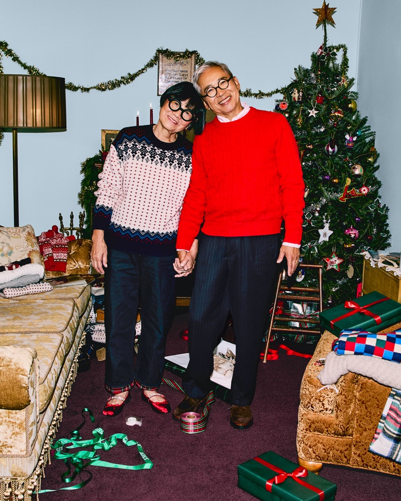 Aki Kim and Koichi Kim standing together holding hands in a festive living room for J. Crew Holiday 2025.