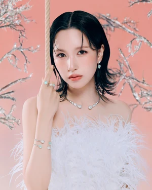Mina wearing a white feather top and diamond jewelry against a pink background for Boucheron