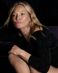 Kate Moss wearing diamond jewelry and a black outfit against a dark background for Messika Festive 2025 campaign.