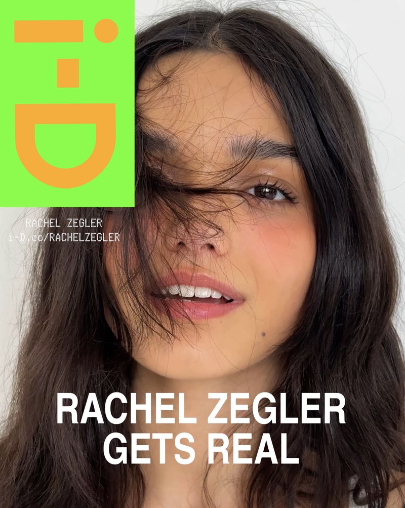 Close-up of Rachel Zegler with dark wavy hair partially covering her face, combined with the bold i-D magazine logo and text overlay.