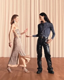 Two models posing against draped curtains and a wooden floor for Rabanne Resort 2026 Party, photographed by Romain Laprade.