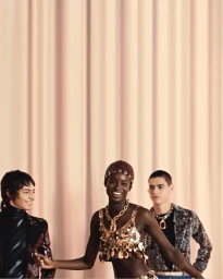 Three models wearing metallic partywear standing against vertical draped curtains for Rabanne Resort 2026