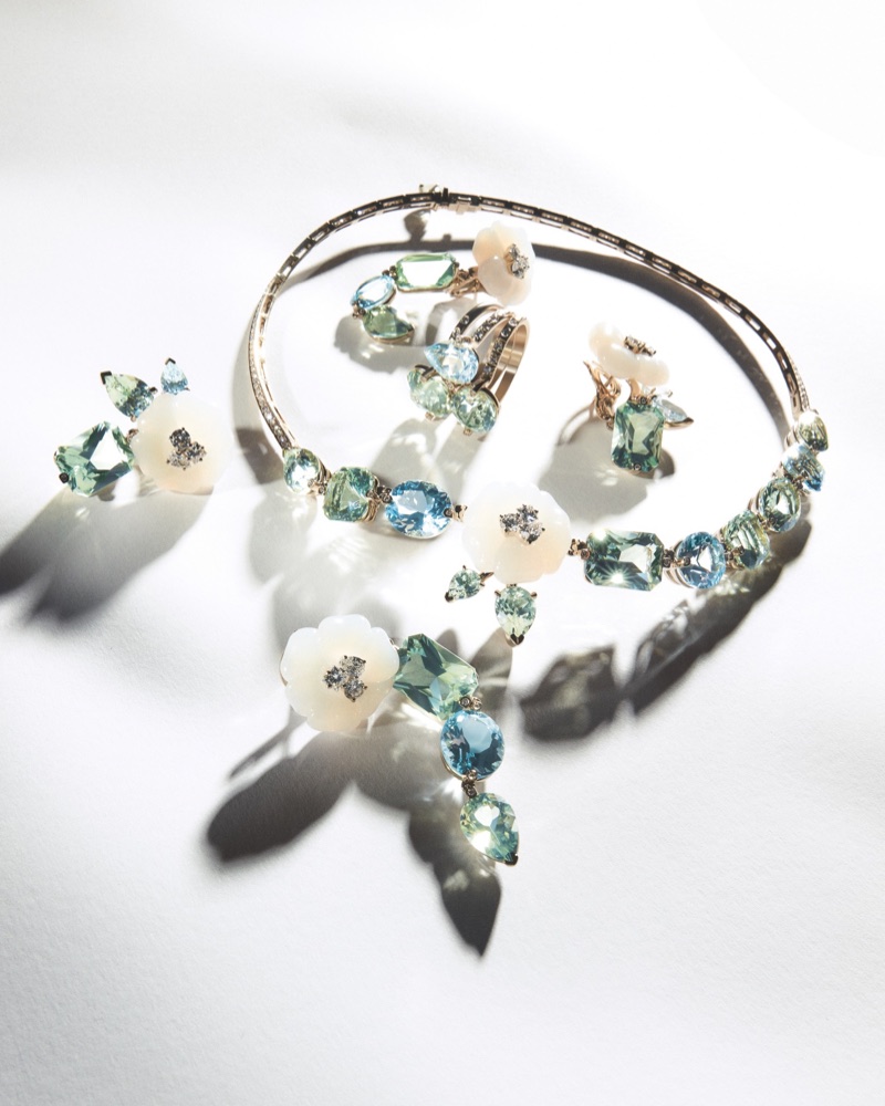 Giorgio Armani high jewellery set with white carved flowers and pastel gemstones casting shadows on a white surface.