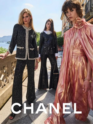 Three female models posing outdoors on a sunny terrace overlooking a body of water for Chanel Cruise 2026 campaign.