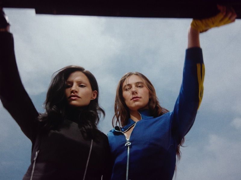 Low-angle shot of Gabbriette and Devon Lee Carlson posing against an open sky in the adidas Originals x Miaou collaboration campaign.