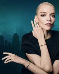 Anya Taylor-Joy wearing jewellery in a dark top against a moody cityscape background for Tiffany and Co.