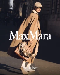 Model Edie Campbell wearing a camel coat and baseball cap carrying a brown leather bag on a city street for Max Mara Icons 2025