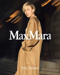 Edie Campbell modeling a camel coat for Max Mara, photographed at night with motion-blurred lights by Oliver Hadlee Pearch.