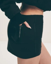 Close-up of Kylie Jenner in black denim miniskirt with hand in pocket for Khy Canvas Collection campaign