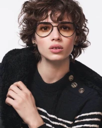 Model Mathilda Gvarliani wearing aviator sunglasses and a black sweater for Chanel Fall-Winter 2025 campaign.