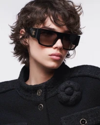 Model Mathilda Gvarliani wearing Chanel sunglasses and a black tweed jacket against a white background.