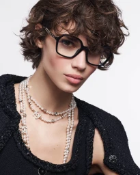 Model Mathilda Gvarliani wearing black eyeglasses and layered pearl necklaces for Chanel Fall-Winter 2025 Campaign